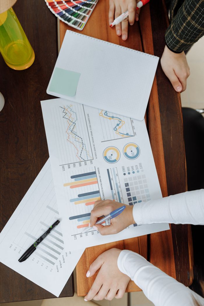 who-we-are Top view of business team analyzing charts and data on paper for strategic planning.